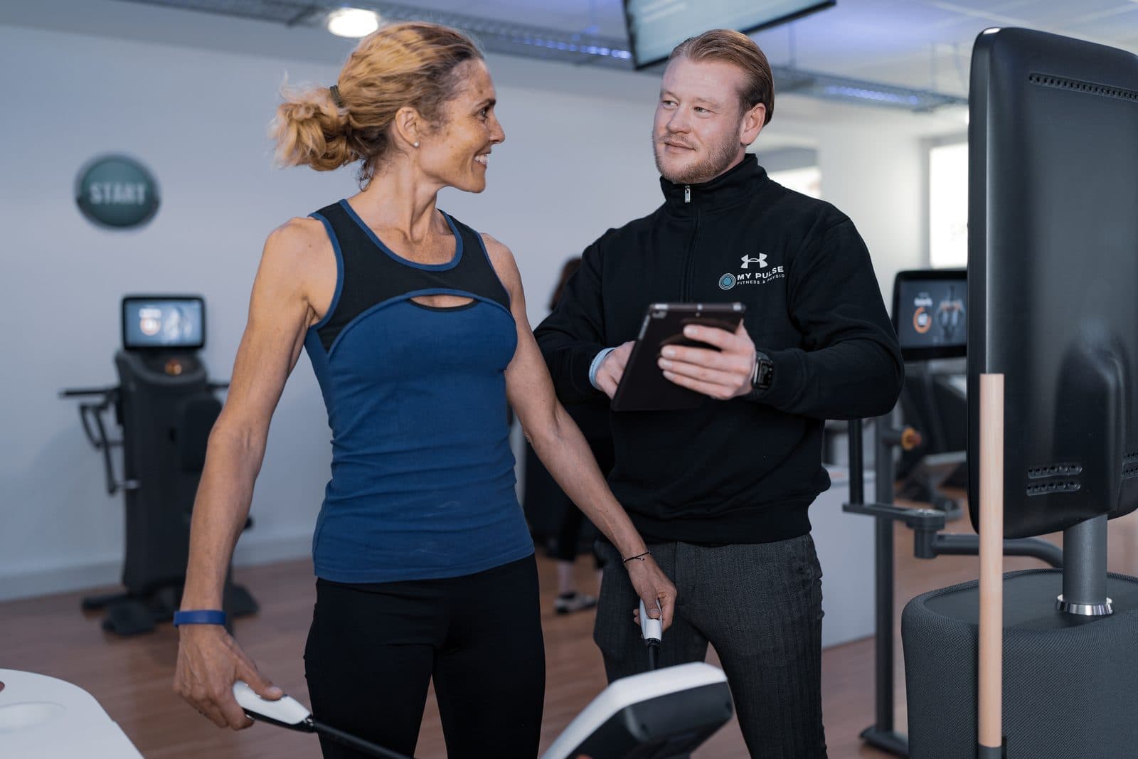 Trainer erklärt Kundin die InBody-Analyse in Bonn